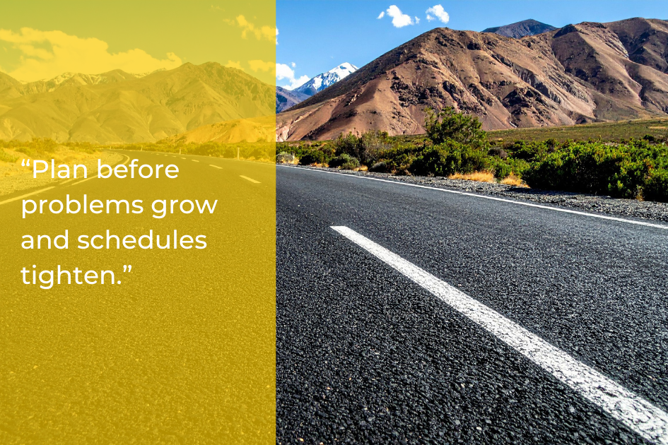 A straight, empty road runs toward mountains under a blue sky. A yellow overlay on the left displays the text: “Plan before problems grow and schedules tighten.” Perfect timing for asphalt paving before winter arrives.